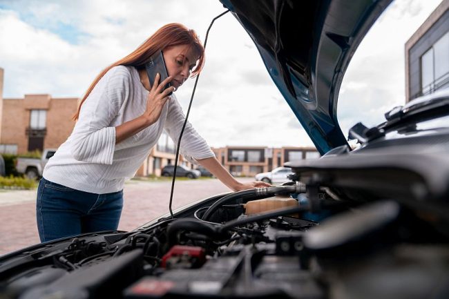 Woman calling the mechanic after her car broke down